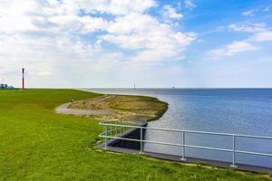 Beautiful coastal dike landscape panorama water stones fields forest Germany. photo