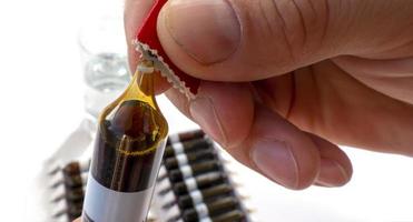 Group of ampoules with a transparent medicine in medical laboratory. lot of ampoules on light background. photo