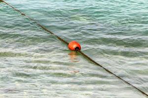 cuerda de cáñamo con boyas en la playa de la ciudad foto