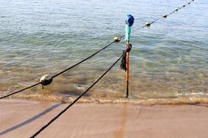 cuerda de cáñamo con boyas en la playa de la ciudad foto