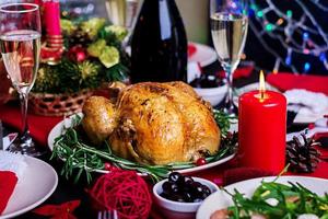 Baked turkey. Christmas dinner. The Christmas table is served with a turkey, decorated with bright tinsel and candles. Fried chicken, table.  Family dinner. photo