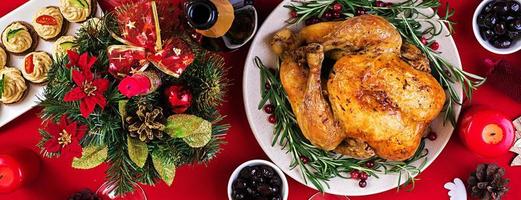 Baked turkey. Christmas dinner. The Christmas table is served with a turkey, decorated with bright tinsel and candles. Fried chicken, table.  Family dinner. Top view photo