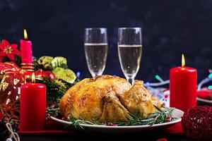 Baked turkey. Christmas dinner. The Christmas table is served with a turkey, decorated with bright tinsel and candles. Fried chicken, table.  Family dinner. photo