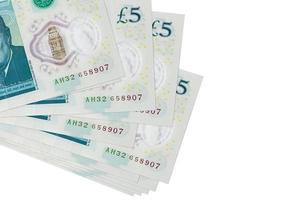 5 British pounds bills lies in small bunch or pack isolated on white. Mockup with copy space. Business and currency exchange photo