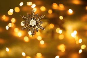 glittering snowflake on a yellow background. Golden lights of the holiday background. Bokeh, blurring, sparks. New Year photo