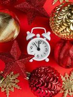 Happy New Year greeting card. Christmas and New Year decor. Christmas balls, stars and clocks on a bright red festive background photo