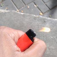 a gas lighter that is red or orange in the palm of the hand photo