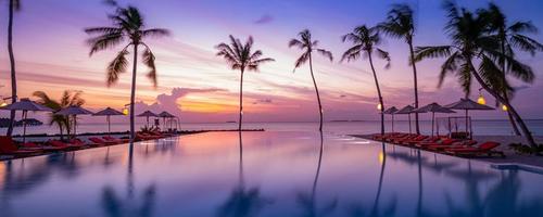 Outdoor luxury sunset over infinity pool swimming summer beachfront hotel resort, tropical landscape. Beautiful tranquil beach holiday vacation background. Amazing island sunset beach view, palm trees photo