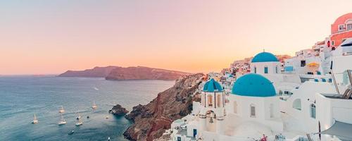 Fantastic Mediterranean Santorini island, Greece. Amazing romantic sunrise in Oia background, morning light. Amazing sunset view with white houses blue domes. Panoramic travel landscape. Lovers island photo