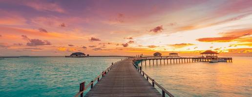 Beautiful Maldives paradise sunset. Tropical aerial landscape, seascape, water villas amazing sea sky, lagoon beach, tropical nature. Exotic tourism destination, summer aerial vacation, drone view.