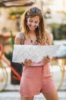 mujer viajando con un mapa y explorando una ciudad extranjera foto