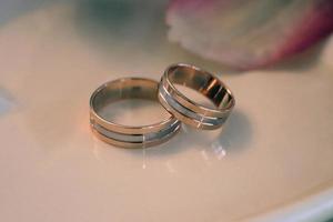 anillos de boda en un platillo blanco foto