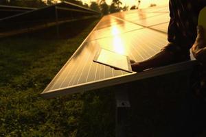 Engineer examining photovoltaic system, silhouette. - picture