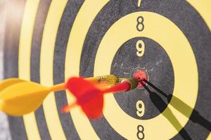 The dart board has yellow and red dart pins, the light that shines through them. photo