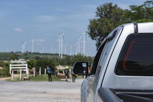 The car parked at the entrance to the windmill field,windmill field blurred background. photo