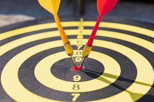 The dart board has yellow and red dart pins, the light that shines through them. photo