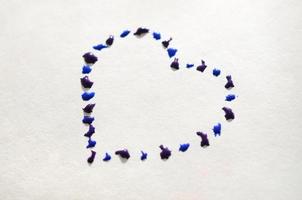 Image of a heart made from wet drops of watercolor paint on a paper sheet photo