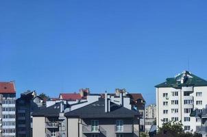 Roofs of modern houses under a cloudless sky. Metal roofing method photo