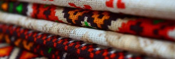 Stack of traditional Ukrainian folk art knitted embroidery patterns on textile fabric photo