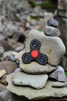 A wooden spinner lies on strange stone structures in the forest photo