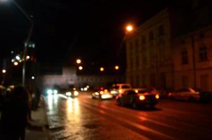 escena nocturna borrosa de tráfico en la carretera. imagen desenfocada de coches que viajan con faros luminosos. arte bokeh foto