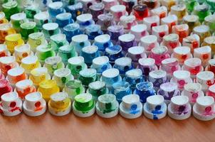 A pattern from a many nozzles from a paint sprayer for drawing graffiti, smeared into different colors. The plastic caps are arranged in many rows forming the color of the rainbow photo