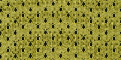 Background image of a fabric texture of a yellow jersey made of polyester nylon. Macro photo with shallow depth of field