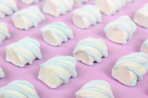 Colorful marshmallow laid out on pink paper background photo