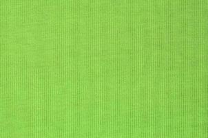 The texture of the fabric is bright green. Material for making shirts and blouses photo