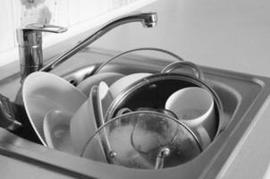 Dirty dishes and unwashed kitchen appliances filled kitchen sink photo