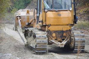 agregado de cantera con maquinaria pesada. Excavadora de oruga con retroexcavadora que conduce a la cantera del sitio de construcción foto