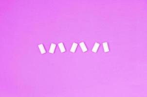 A few chewing gums lie on texture background of fashion pastel purple color paper photo