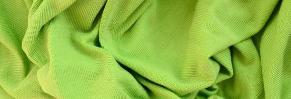 The texture of the fabric is bright green. Material for making shirts and blouses photo