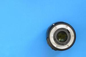 One photographic lense lie on a bright blue background. Space for text photo