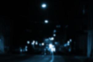 Blurred night scene of traffic on the roadway. Defocused image of cars traveling with luminous headlights. Bokeh Art photo