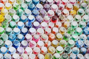 un patrón de muchas boquillas de un rociador de pintura para dibujar graffiti, manchado en diferentes colores. las tapas de plástico están dispuestas en muchas filas formando el color del arco iris foto