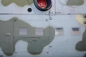 Side part texture of military helicopter painted in camouflage. Old armoured aircraft photo