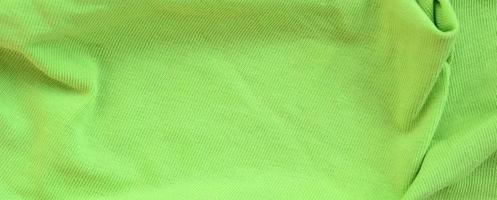 The texture of the fabric is bright green. Material for making shirts and blouses photo