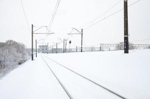 paisaje ferroviario de invierno, vías férreas en el país industrial cubierto de nieve foto