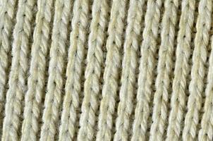Fabric texture of a soft yellow knitted sweater. Macro image of the structure of bindings in yarns photo