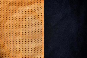 Close up of orange polyester nylon sportswear shorts to created a textured background photo