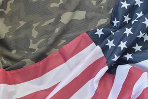 bandera de los estados unidos de américa y chaqueta de uniforme militar doblada. banner de fondo conceptual de símbolos militares para fiestas patrióticas americanas foto