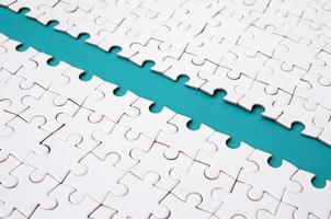 The blue path is laid on the platform of a white folded jigsaw puzzle. Texture image with copy space for text photo
