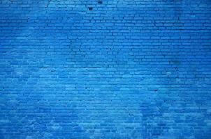 la textura de la pared de ladrillo de muchas filas de ladrillos pintados de color azul foto