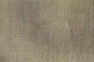 Texture of a gray canvas made of old and coarse burlap. Top view photo