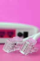 Internet router and Internet cable plugs lie on a bright pink background. Items required for Internet photo