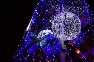 fragmento del árbol de año nuevo. muchas luces redondas de color azul están ubicadas en un marco cónico foto