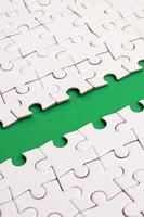 The green path is laid on the platform of a white folded jigsaw puzzle. Texture image with copy space for text photo