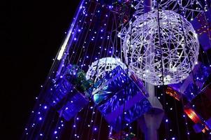 Fragment of the New Year tree. A lot of round lights of blue color are located on a conical frame photo