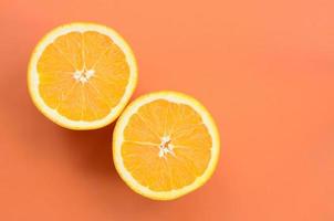 Top view of a several orange fruit slices on bright background in orange color. A saturated citrus texture image photo